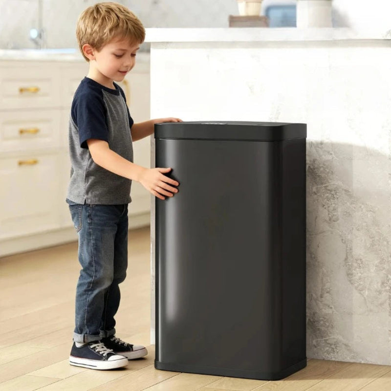Un enfant à côté d'une poubelle automatique noire 45L